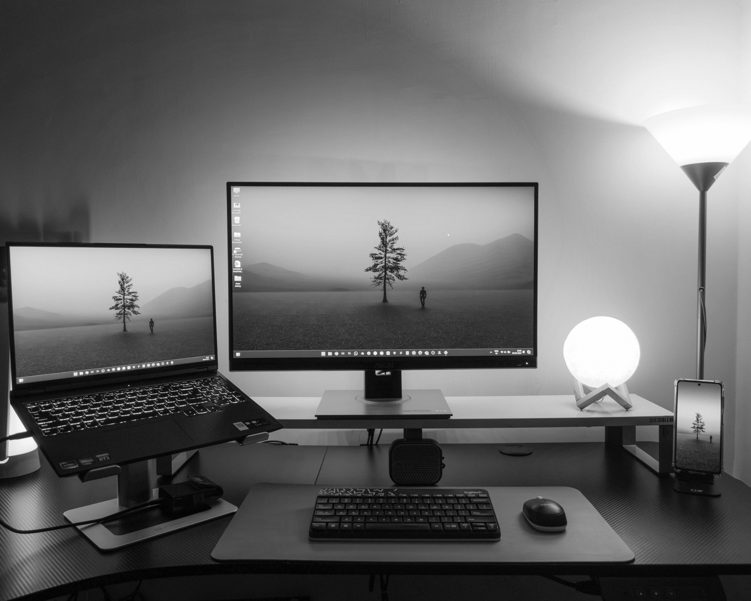 A desk with two monitors and a keyboard