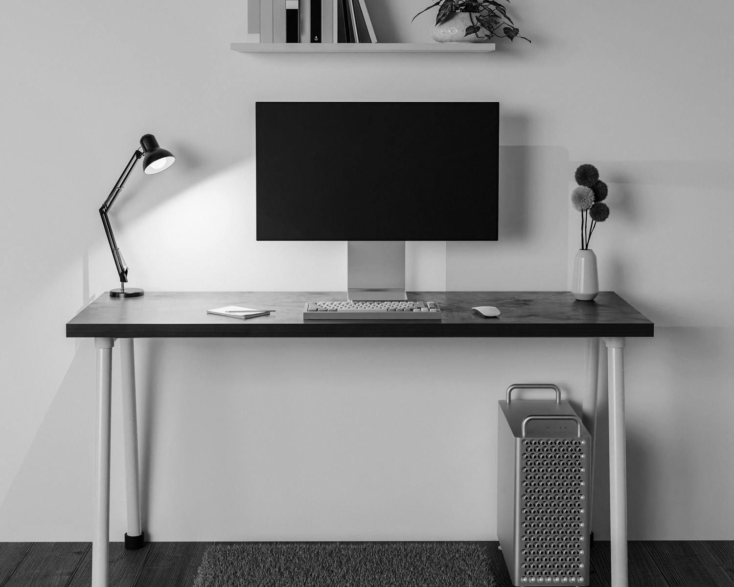a computer desk with a monitor and a lamp