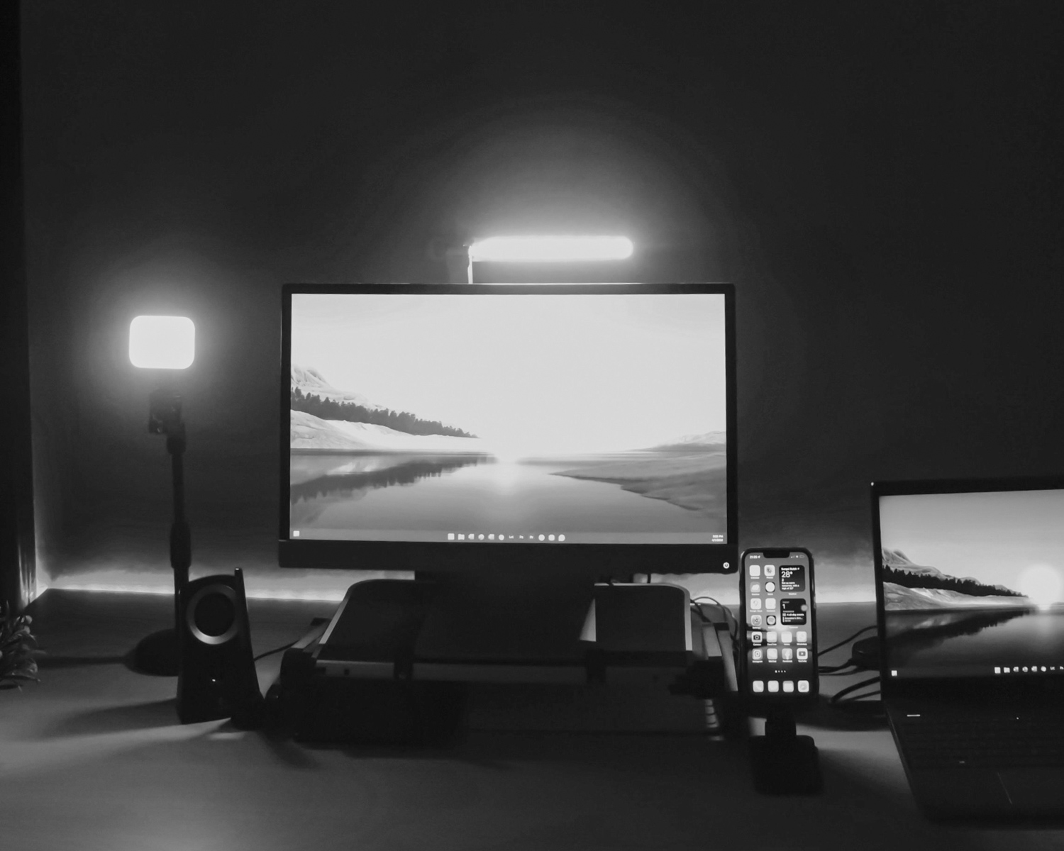 a desk with two monitors and a cell phone