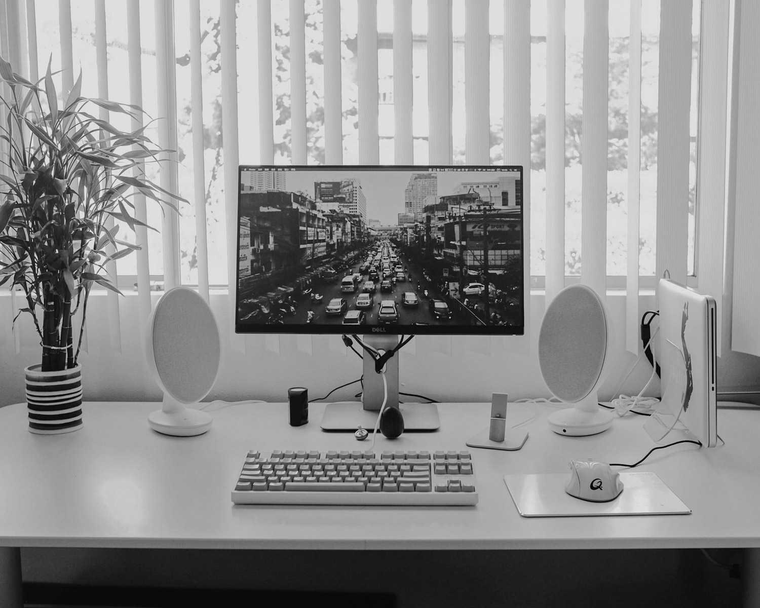 black flat screen computer monitor; keyboard; speakers; mouse on desk
