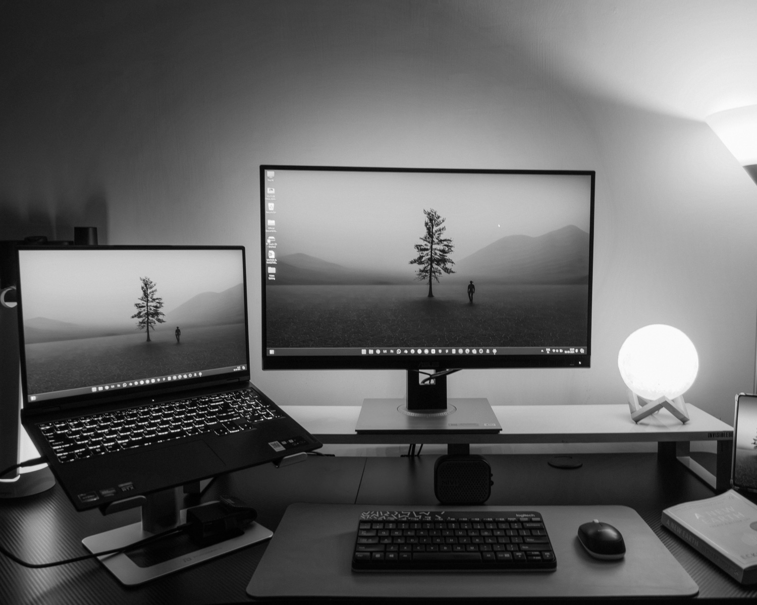 A computer desk with two monitors and a keyboard