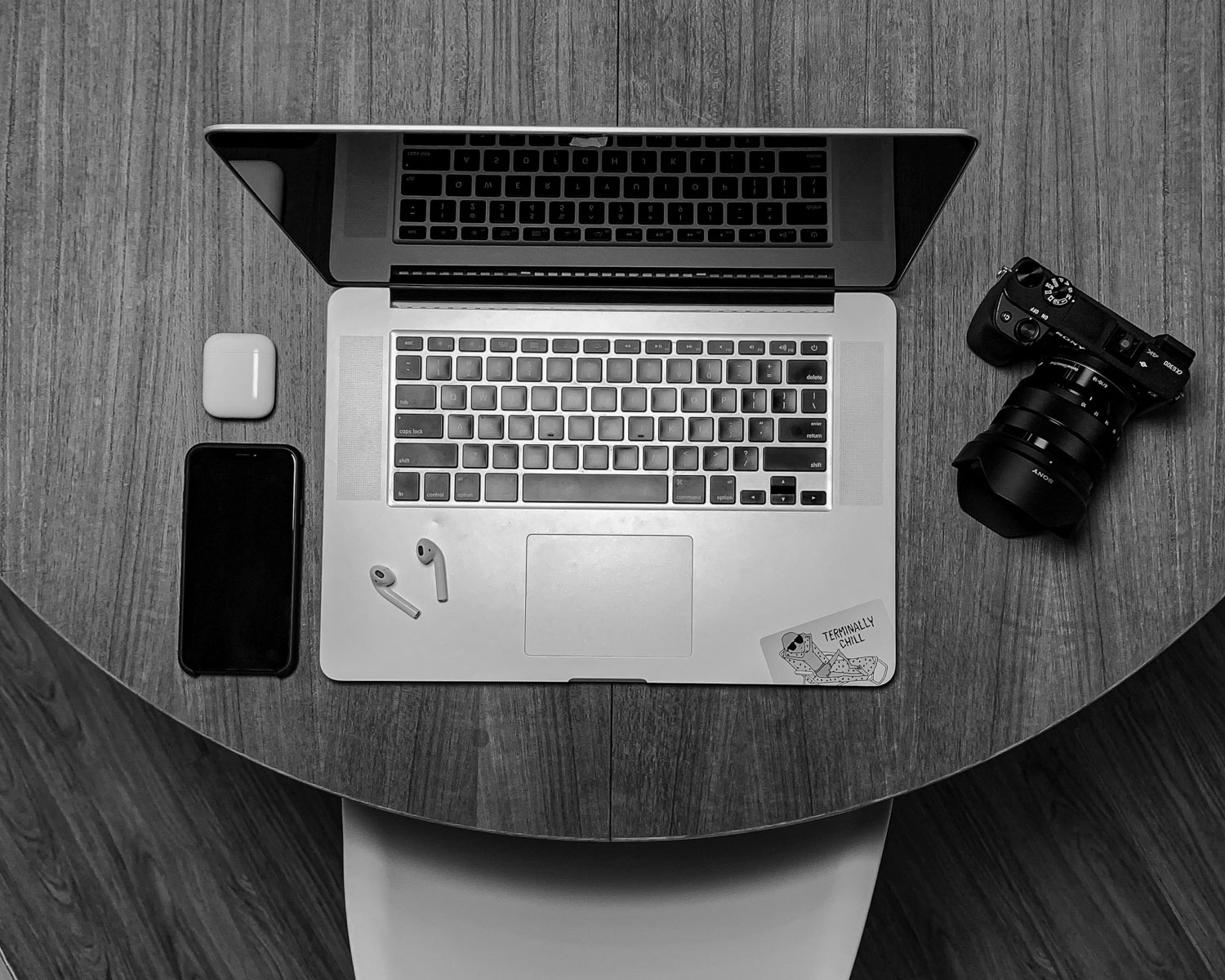 black and silver laptop computer beside black dslr camera on brown wooden table