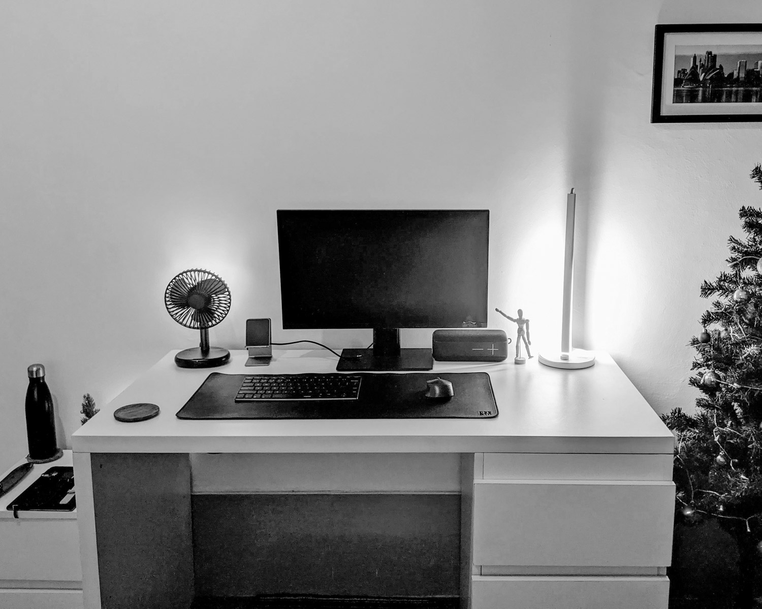 a desk with a computer and a christmas tree