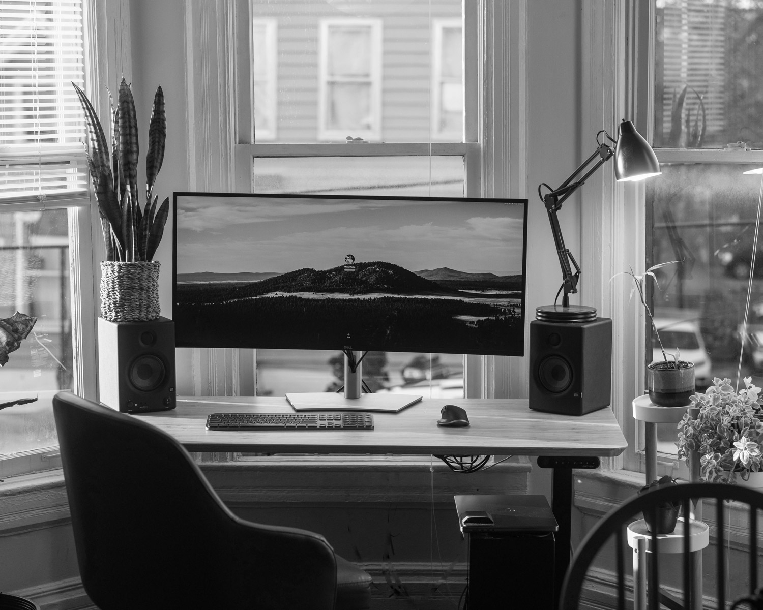a desk with a computer on it in front of a window