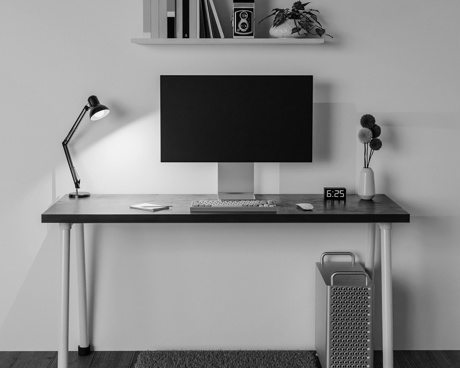 a desk with a computer monitor and a lamp