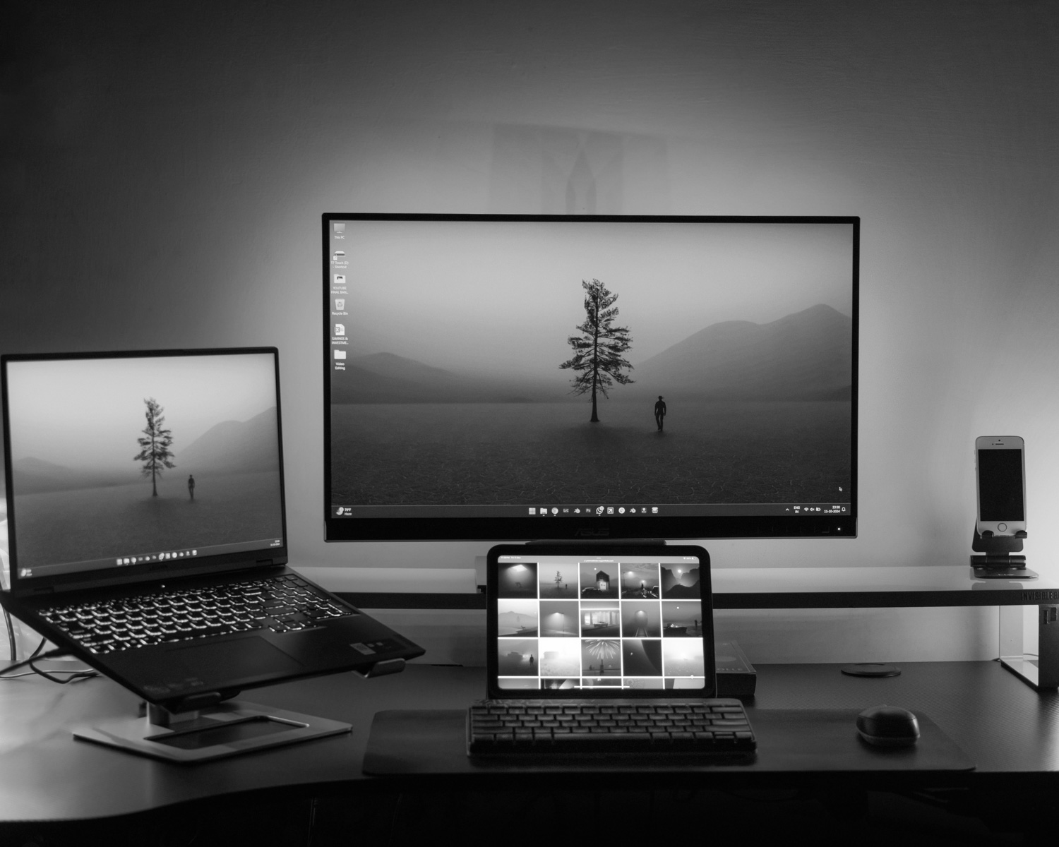 A desk with two monitors and a laptop
