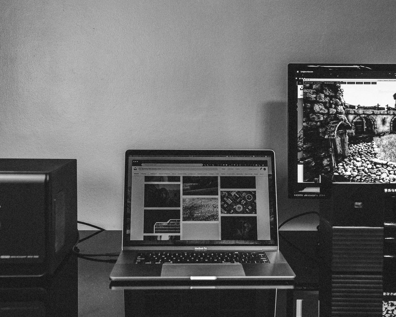 turned-on MacBook beside monitor