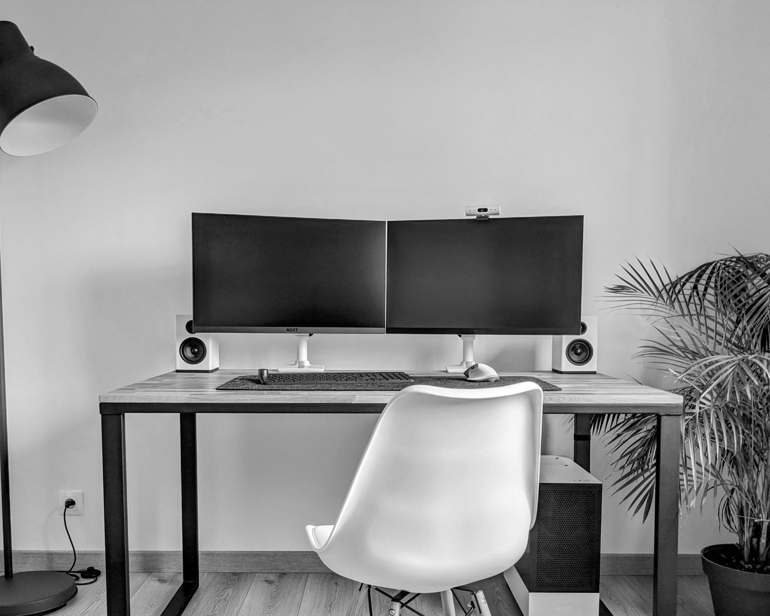 a desk with two computer monitors and a chair