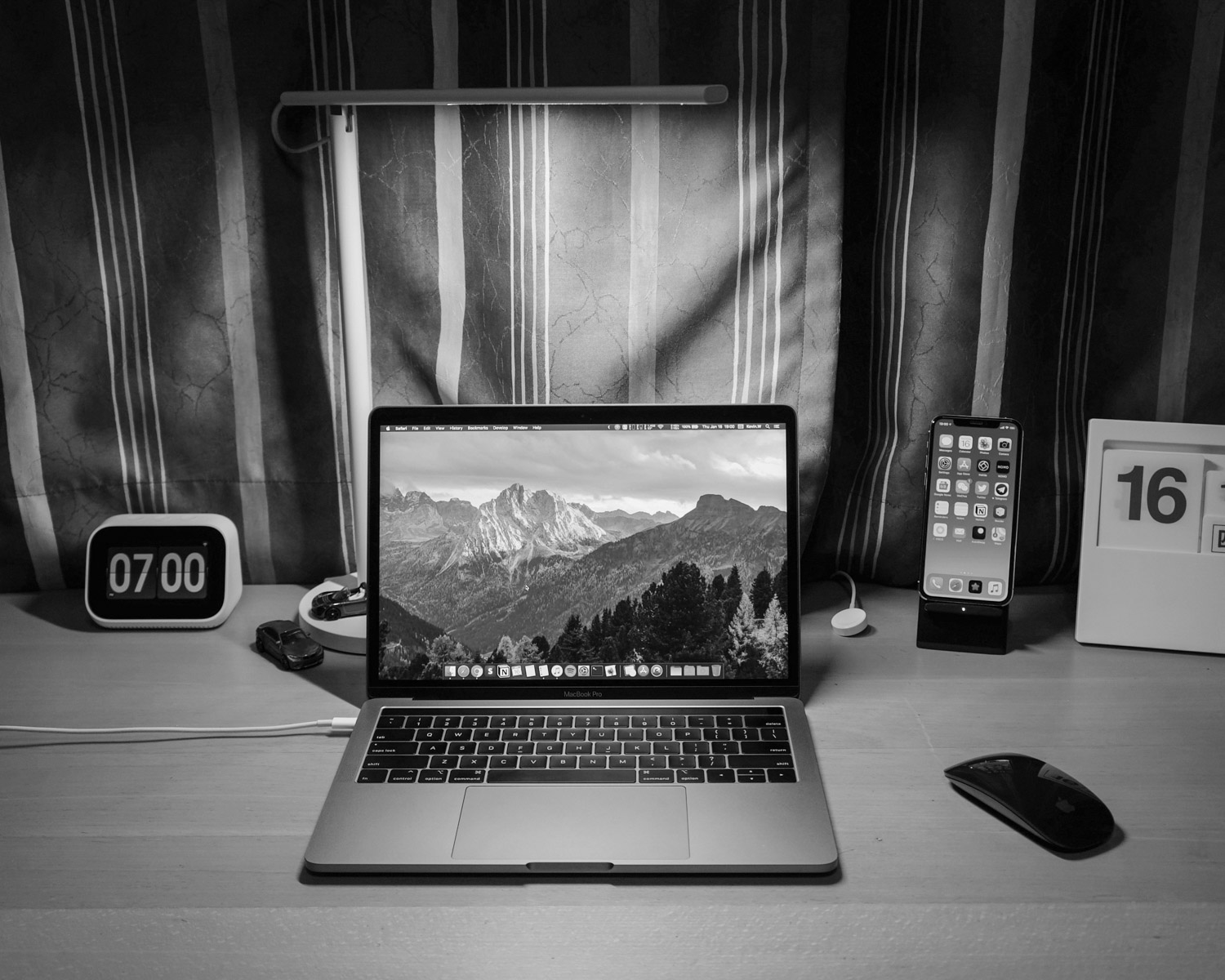 macbook pro beside black iphone 4 on brown wooden table
