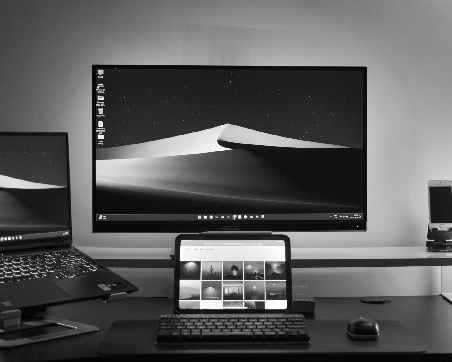 A desk with two monitors and a laptop