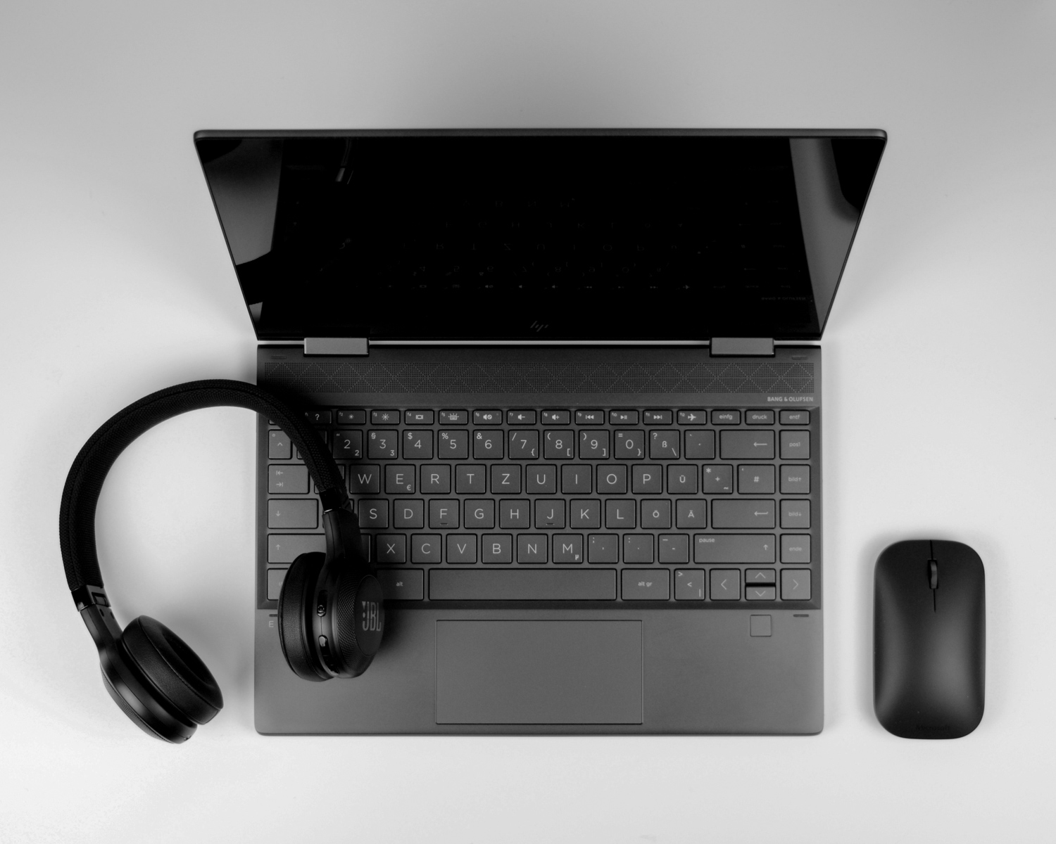 a laptop computer with headphones and a mouse