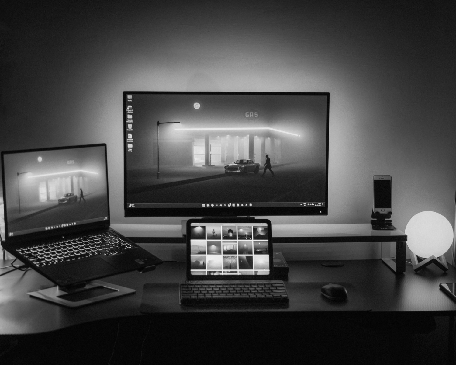 A desk with two monitors and a laptop