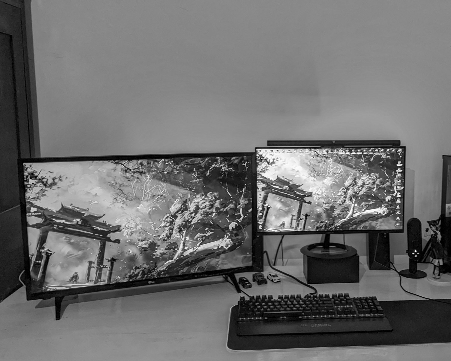 a desk with a keyboard and two monitors